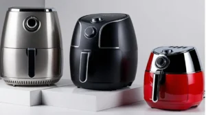 Symbolbild, auf denen drei verschiedene Airfryer-Modelle nebeneinanderstehen. 