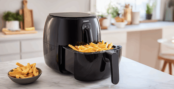 Philipps 3000 Airfryer im Test. Der Airfryer ist auf einem weißen Küchencounter und hat Pommes in der Schale