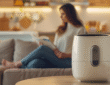 Leiser Airfryer – so leise dass man daneben entspannen kann, wie diese Frau die auf dem Sofa ein Buch liest.