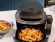 Philips 5000 Series Steam test - Der Airfryer steht in einer Küche mit knusprig gegarten Pommes