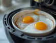 Eier im Airfryer - 2 Spiegeleier sind im Garkorb eines Airfryers
